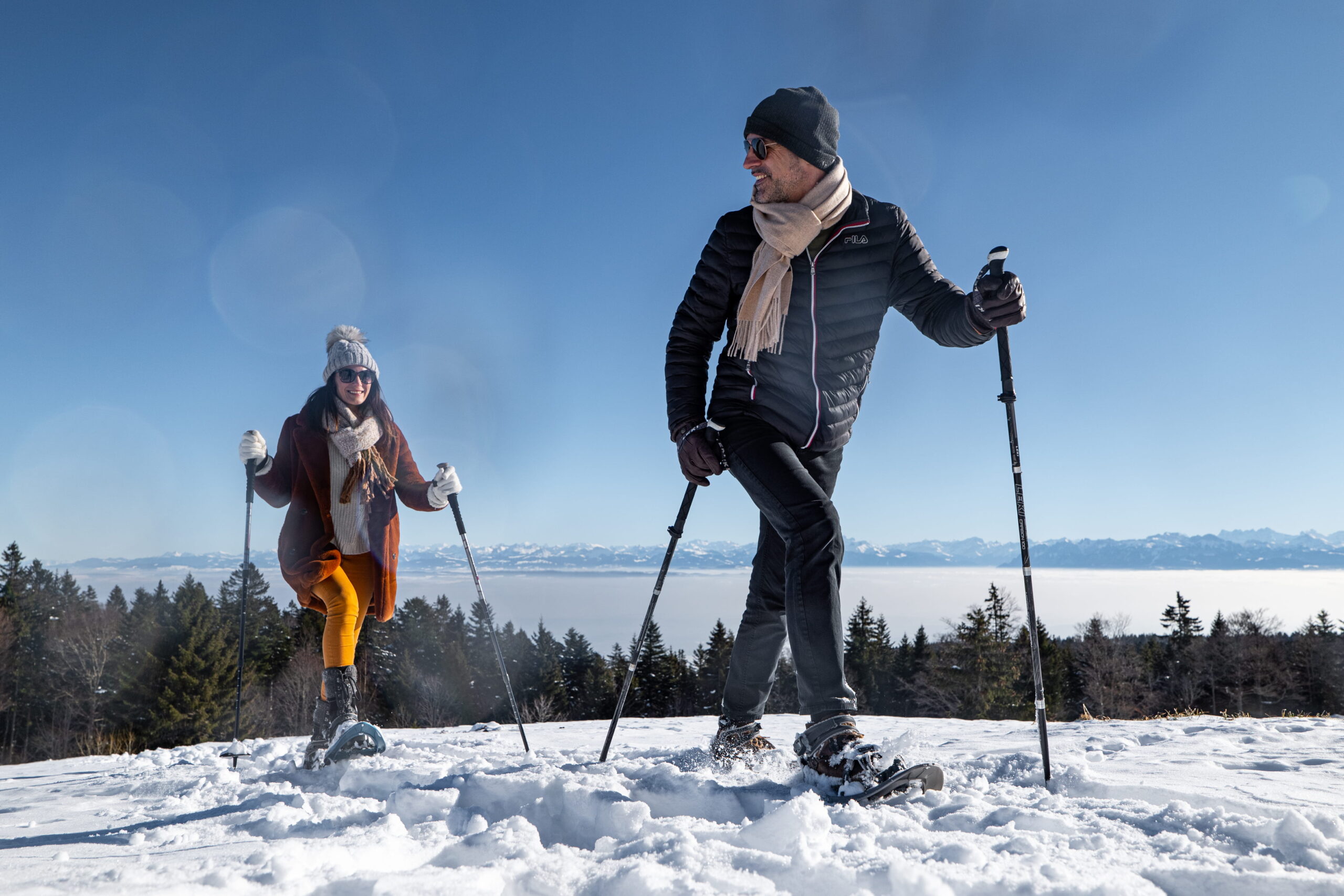 Couple se baladant avec des raquettes à neige sur un itinéraire balisé de la Vallée de Joux.
